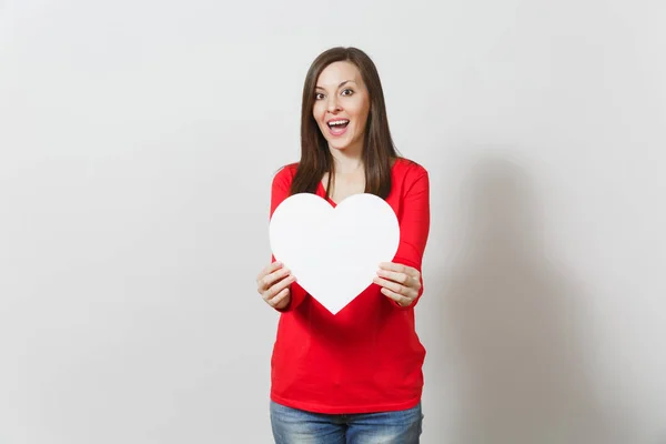Hübsche Frau in roter Kleidung, die ein großes weißes Herz in den Händen hält, isoliert auf weißem Hintergrund. Kopierfläche für Werbung. mit Platz für Text. St. Valentinstag oder Internationaler Frauentag. — Stockfoto