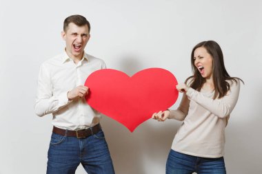 Aşık genç bir çift. Erkek ve kadın beyaz arka plan üzerinde izole kırmızı bir kalp ile. St. Valentine's Day, Dünya Kadınlar Günü, doğum günü, konsept tatil. Kavga boşanma break up ilişki