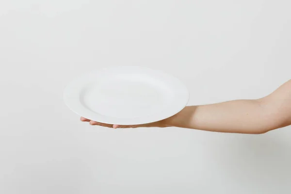 Primer plano de la mano femenina horizontal sosteniendo placa redonda blanca aislada sobre fondo blanco. concepto de utensilios de cocina. Copiar espacio para publicidad . — Foto de Stock