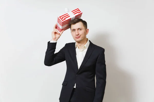 Молодой ошеломленный мужчина в костюме надевает красную коробку с подарком на белом фоне. Копировать место для рекламы. День святого Валентина, Международный женский день, день рождения, праздничная концепция . — стоковое фото