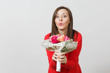 Beyaz zemin üzerine kırmızı giysili güzel gül buket tutan genç gülümseyen kadın izole. Reklam için yer kopyalayın. Sevgililer günü veya Dünya Kadınlar Günü kavramı.