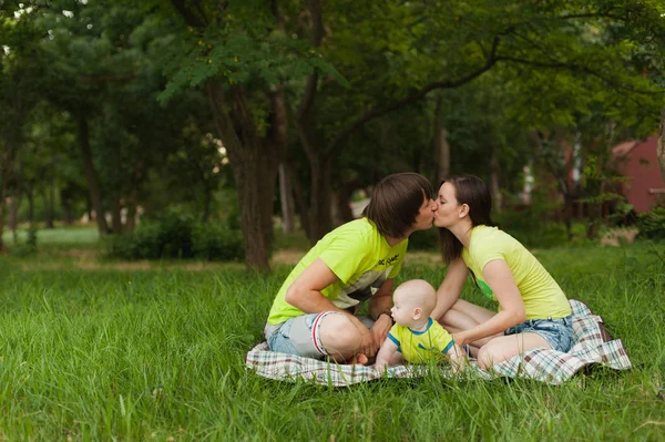 Joyful fun man, woman walking on picnic kissing, hugging, playing with little cute child baby boy. Mother, father, little kid son. Parenthood, family day 15 of may, love, parents, children concept. — Stock Photo, Image