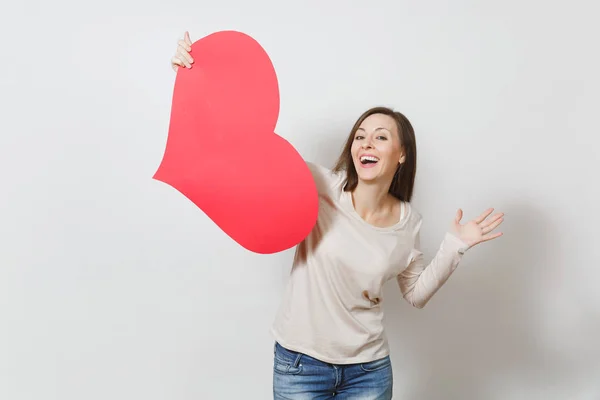 Attractive young smiling woman holding big red heart in hands is — Stock Photo, Image