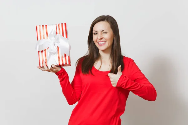 Mulher mostrando polegar para cima, segurando caixa de presente listrado vermelho com fita isolada em fundo branco. Para publicidade. Dia de São Valentim, Dia Internacional da Mulher, Natal, aniversário, conceito de feriado — Fotografia de Stock