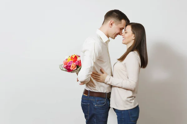 Pareja enamorada. Mujer mirando detrás del hombre que se esconde detrás de él ramo de hermosas rosas flores aisladas sobre fondo blanco. Día de San Valentín, Día Internacional de la Mujer concepto de fiesta de cumpleaños —  Fotos de Stock