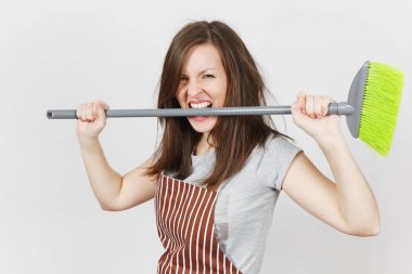 Genç deli baş döndürücü kaçık vahşi agresif ev kadını çizgili önlük beyaz arka plan üzerinde izole kahverengi tousled saçlı eğlenceli. Holding, diş süpürge ısırma cadı kadın. Kopya alanı reklam için.