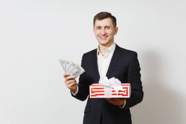 Kırmızı mevcut kutu hediye, bohça-in nakit para ile beyaz arka plan üzerinde izole dolar tutan takım elbiseli genç yakışıklı adam. Sevgililer günü, Dünya Kadınlar Günü, doğum günü tatil kavramı.