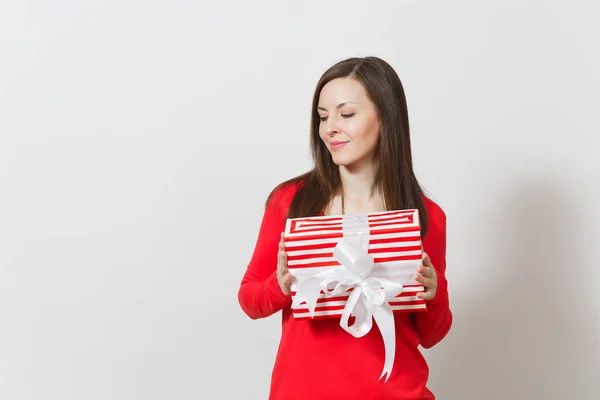 Mulher sorrindo segurando caixa de presente listrado vermelho com fita, arco isolado em fundo branco. Para publicidade. Dia de São Valentim, Dia Internacional da Mulher, Natal, aniversário, conceito de feriado . — Fotografia de Stock
