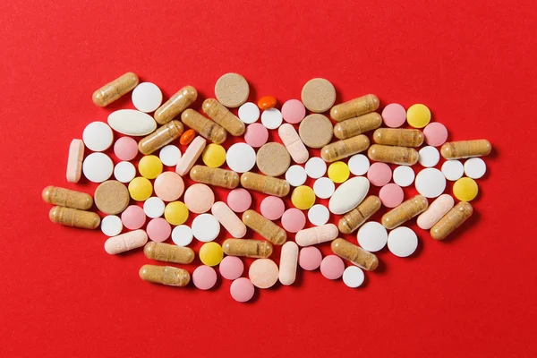 Medicamento blanco colorido redondo tabletas dispuestas abstracto sobre fondo de color rojo. Aspirina, cápsulas para el diseño. Salud, tratamiento, elección concepto de estilo de vida saludable. Copiar espacio para publicidad . — Foto de Stock