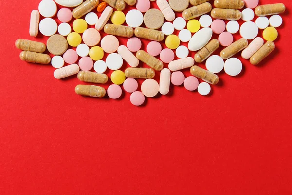 Medicamento blanco colorido redondo tabletas dispuestas abstracto sobre fondo de color rojo. Aspirina, cápsulas para el diseño. Salud, tratamiento, elección concepto de estilo de vida saludable. Copiar espacio para publicidad . — Foto de Stock