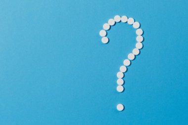 İlaç tablet beyaz mavi renk arka plan üzerinde izole söz konusu işareti şekli düzenlenmiştir. Hap, işareti. Sağlık, tedavi, seçim, sağlıklı yaşam kavramı. Kopya alanı reklam için.