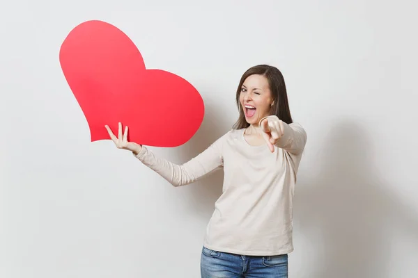 Bastante divertido joven sonriente mujer sosteniendo gran corazón rojo en las manos es —  Fotos de Stock