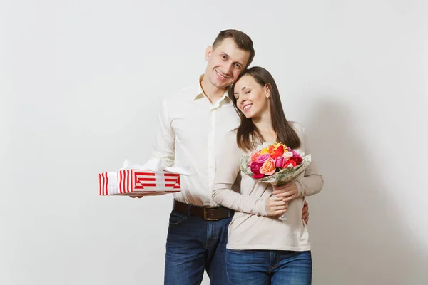 Young couple in love. Man and woman with bouquet of beautiful roses flowers, present box with gift isolated on white background. St. Valentine's Day, International Women's Day birthday holiday concept — Stock Photo, Image