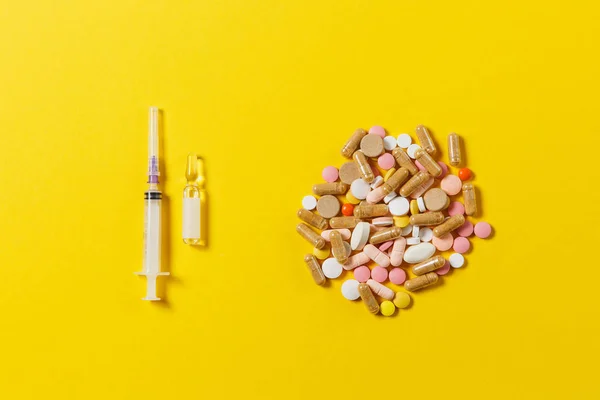 Medicatie kleurrijke ronde capsule, tabletten, pillen geregeld abstract op gele achtergrond. Aspirine, ampul, lege spuit-naald. Gezondheid, behandeling, keuze, gezonde levensstijl concept. Kopiëren van ruimte. — Stockfoto