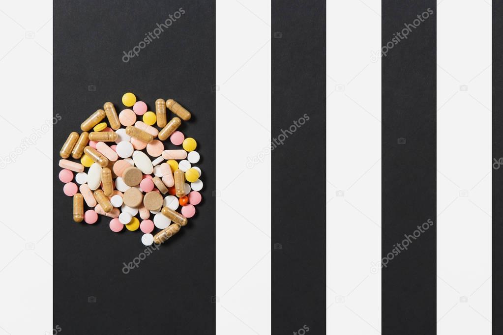 Medication white colorful round tablets arranged abstract on white black background. Aspirin, capsule pills design. Health, treatment, choice healthy lifestyle concept. Copy space for advertisement.