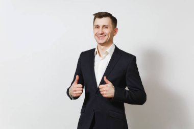 Yakışıklı memnun beyaz şanslı genç mutlu iş adamı reklam için 25-30 yıl içinde koyu takım elbise, beyaz arka plan üzerinde başparmak gösterilmesini ışık gömlek izole.