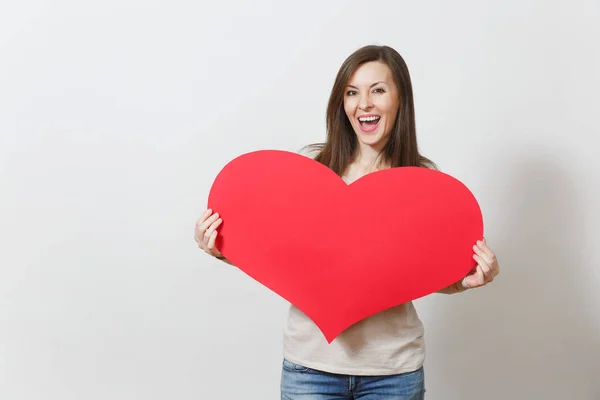 Schöne junge lächelnde Frau hält großes rotes Herz in den Händen iso — Stockfoto