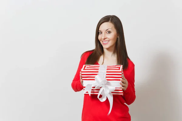 Mulher sorrindo segurando caixa de presente listrado vermelho com fita, arco isolado em fundo branco. Para publicidade. Dia de São Valentim, Dia Internacional da Mulher, Natal, aniversário, conceito de feriado . — Fotografia de Stock