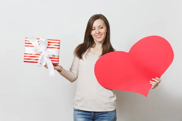 Schöne junge lächelnde Frau mit großem roten Herz, Schachtel mit Geschenk auf weißem Hintergrund. Kopierfläche für Werbung. mit Platz für Text. St. Valentinstag oder Internationaler Frauentag. — Stockfoto