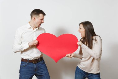Aşık genç bir çift. Erkek ve kadın beyaz arka plan üzerinde izole kırmızı bir kalp ile. St. Valentine's Day, Dünya Kadınlar Günü, doğum günü, konsept tatil. Kavga boşanma break up ilişki