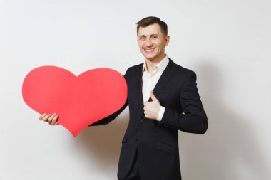 Beyaz arka plan üzerinde izole büyük kırmızı kalp tutan yukarı başparmak gösterilen takım elbiseli genç adam. Alan, reklam kopyalayın. Metin için yer. St. Valentine's Day, Uluslararası Kadınlar günü doğum günü tatil kavramı.