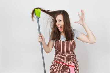 Genç tousled deli baş döndürücü kaçık vahşi agresif ev kadını saç beyaz arka plan üzerinde izole cebinde çizgili önlük eğlenceli. Tousled kumral süpürge tarafından dışarı deli kadın tarak. Kopya alanı reklam için