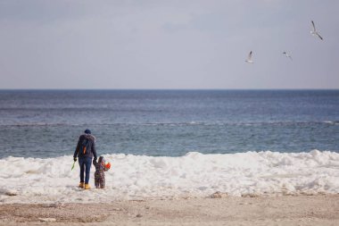 Kadın oyun bakmak denizde kar beach küçük şirin çocuk oğlu ile tulum ile oyuncak araba içinde kürek. Anne, çocuk evlat eğlenceli kış günü. Aile tatil 15 anne çocuk kavramı çok. Arkadan Görünüm