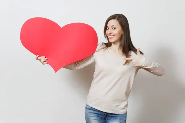 Attraktive junge lächelnde Frau zeigt großes rotes Herz in den Händen — Stockfoto