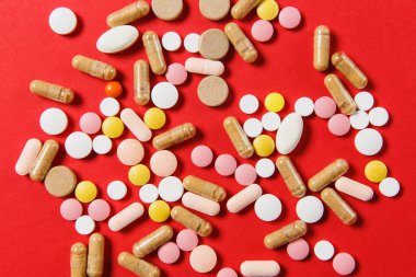 İlaç beyaz renkli yuvarlak tablet soyut kırmızı renk arka plan üzerinde düzenlenmiştir. Aspirin, tasarım için kapsül hap. Sağlık, tedavi, sağlıklı yaşam kavramı. Kopya alanı reklam için.