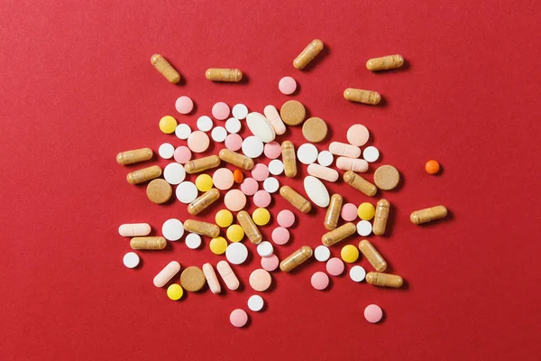 Medicamento blanco colorido redondo tabletas dispuestas abstracto sobre fondo de color rojo. Aspirina, cápsulas para el diseño. Salud, tratamiento, elección concepto de estilo de vida saludable. Copiar anuncio de espacio . — Foto de Stock