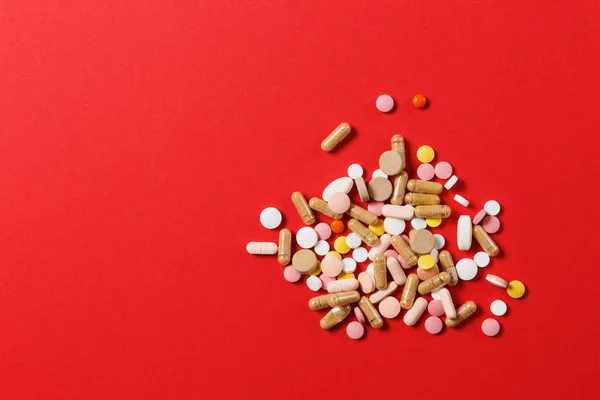 Medicamento blanco colorido redondo tabletas dispuestas abstracto sobre fondo de color rojo. Aspirina, cápsulas para el diseño. Salud, tratamiento, elección concepto de estilo de vida saludable. Copiar espacio para publicidad . — Foto de Stock