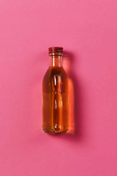 Flaska med alkohol på rosa ros bakgrund. Hälsa, drink, val, hälsosam livsstilskoncept. Kopiera utrymme för annonseringen. Med plats för text. — Stockfoto