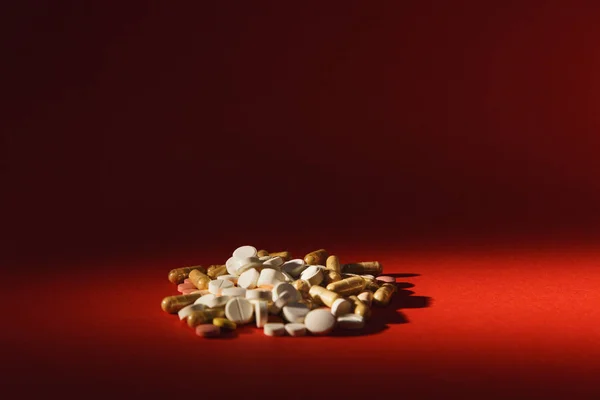 Medicamento blanco colorido redondo tabletas dispuestas abstracto sobre fondo de color rojo oscuro. Aspirina, cápsulas para el diseño. Salud, elección de tratamiento concepto de estilo de vida saludable. Copiar anuncio de espacio . — Foto de Stock