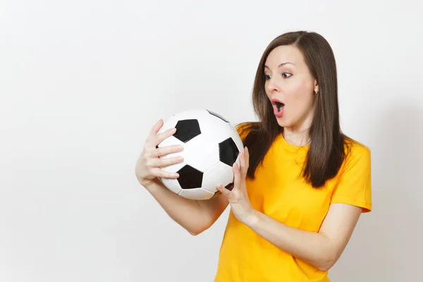 Beautiful European young cheerful happy woman, football fan or player in yellow uniform holding soccer ball isolated on white background. Sport, play football, health, healthy lifestyle concept.