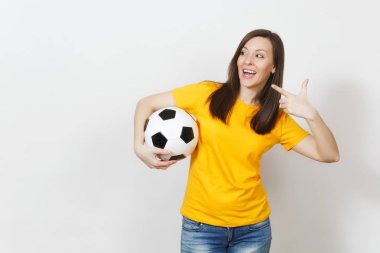 Avrupa genç kadın, futbol fan veya oyuncu futbol topu işaret işaret parmağı bir kenara beyaz arka plan üzerinde izole tutan sarı üniformalı. Spor, oyun futbol, sağlık, sağlıklı yaşam konsepti.
