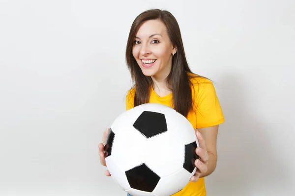 Close up pretty European young smiling happy woman, football fan or player in yellow uniform holding soccer ball isolated on white background. Sport, play football, health, healthy lifestyle concept.
