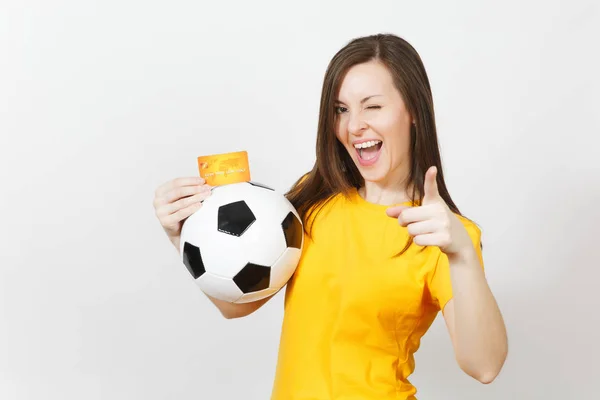Hermosa joven europea alegre mujer, fanático del fútbol o jugador en uniforme amarillo con tarjeta de crédito pelota de fútbol aislado sobre fondo blanco. Deporte, juego de fútbol, emoción concepto de estilo de vida . — Foto de Stock