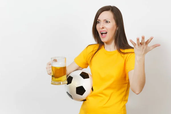 Bastante europeo joven triste mujer molesta, fanático del fútbol o jugador en uniforme amarillo sostiene jarra de cerveza, se preocupa por perder equipo aislado sobre fondo blanco. Deporte, fútbol, concepto de estilo de vida . —  Fotos de Stock