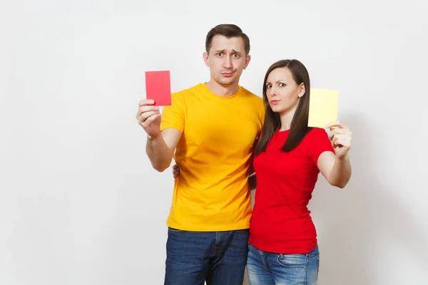 European serious severe young woman and man, football referee hold choose yellow and red soccer cards, propose player retire from field isolated on white background. Sport, play, lifestyle concept. Stock Photo