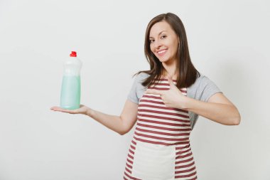 Ev kadını çizgili önlük beyaz arka plan üzerinde izole kamera arıyorum. Temizlikçi kadın işaret parmağı ile bulaşık yıkama için reklam kopya alanı ile temizleyici sıvı şişe şişe üzerinde bir kenara