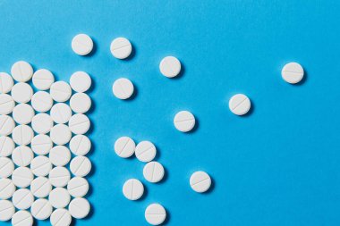 İlaç beyaz yuvarlak mavi renk arka plan üzerinde izole düzenlenmiş tablet soyut. Tasarım için aspirin hap. Sağlık, tedavi, seçim, sağlıklı yaşam kavramı. Kopya alanı reklam için.
