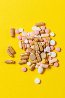 İlaç beyaz renkli yuvarlak tabletler sarı renk arka plan üzerinde soyut düzenlenmiştir. Aspirin, tasarım için kapsül hap. Sağlık, tedavi, sağlıklı yaşam kavramı. Kopyalama alanı reklam.