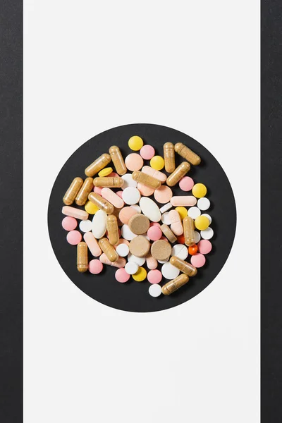 Leki białe kolorowe okrągłe tabletki ułożone Abstrakcja w koło na białym tle czarny. Aspiryna, kapsułki pigułki projekt. Leczenia, wyboru pojęcie zdrowego stylu życia. Miejsce na reklamę. — Zdjęcie stockowe