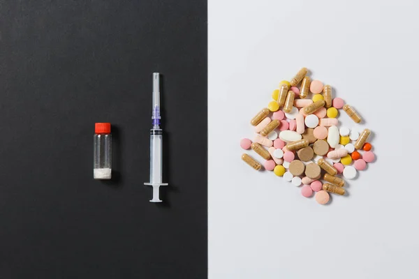 Medicinering färgglada runda tabletter, kapslar, piller ordnade abstrakt på vit svart bakgrund. Acetylsalicylsyra, flaska, Töm sprutans nål. Hälsa, behandling, val, hälsosam livsstilskoncept. Kopiera utrymme. — Stockfoto