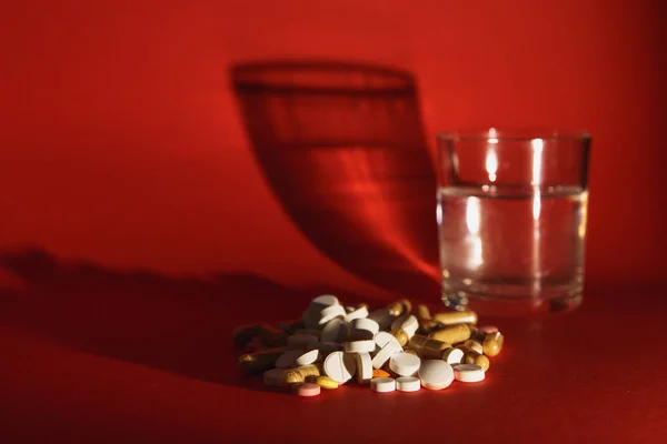 药物白色彩色片剂安排抽象在深红色背景。胶囊玻璃瓶的水丸设计。健康治疗选择健康的生活方式观念。复制空间广告. — 图库照片