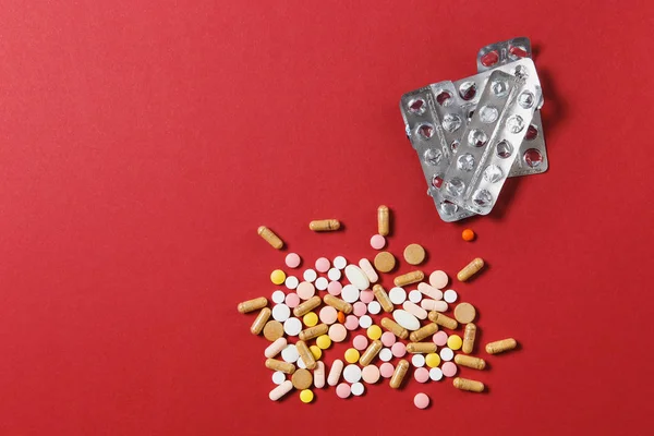 Leki białe kolorowe okrągłe tabletki ułożone Abstrakcja na czerwony kolor tła. Aspiryna, kapsułki pigułki, puste opakowania. Leczenie, wybór pojęcie zdrowego stylu życia. Kopiować miejsca ogłoszenie. — Zdjęcie stockowe