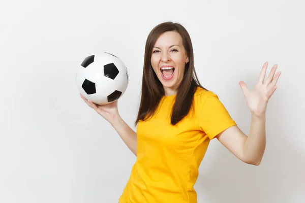 Hermosa joven europea alegre mujer feliz, fanático del fútbol o jugador en uniforme amarillo sosteniendo pelota de fútbol aislado sobre fondo blanco. Deporte, fútbol, salud, concepto de estilo de vida saludable . — Foto de Stock