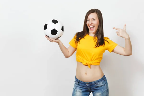 Hermosa joven europea fuerte delgada mujer sexy, fanático del fútbol o jugador en uniforme amarillo sosteniendo pelota de fútbol aislado sobre fondo blanco. Deporte, fútbol, salud, concepto de estilo de vida saludable . — Foto de Stock