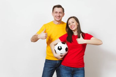 Eğlence gülümseyen genç çift, kadın, erkek, futbol taraftarları destek ekibi beyaz arka plan üzerinde izole futbol topu tutarak sarı ve kırmızı üniforma neşelen. Spor, Aile Eğlence, yaşam kavramı.