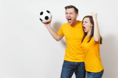 Eğlenceli deli neşeli duygusal genç çift, kadın, erkek, futbol taraftarları destek ekibi ile futbol topu beyaz arka plan üzerinde izole sarı üniforma neşelen. Spor, Aile Eğlence, yaşam kavramı.
